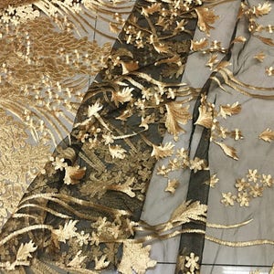 May include: Black mesh fabric with gold embroidery featuring floral and leaf designs.