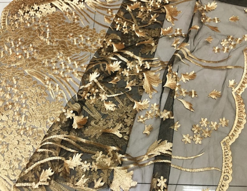 May include: Black mesh fabric with gold embroidery featuring floral and leaf designs.