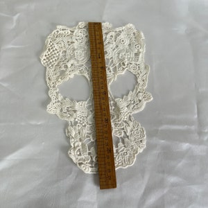 May include: White lace skull applique measuring approximately 29 inches in length. The skull is intricately detailed with floral patterns.