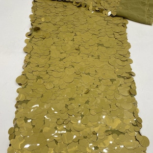 Puede incluir: Una pieza de tela verde oliva densamente cubierta con lentejuelas circulares superpuestas de varios tama&ntilde;os. El tejido presenta un esquema de color verde oliva monocrom&aacute;tico consistente, con el texto Olive Green en la esquina.