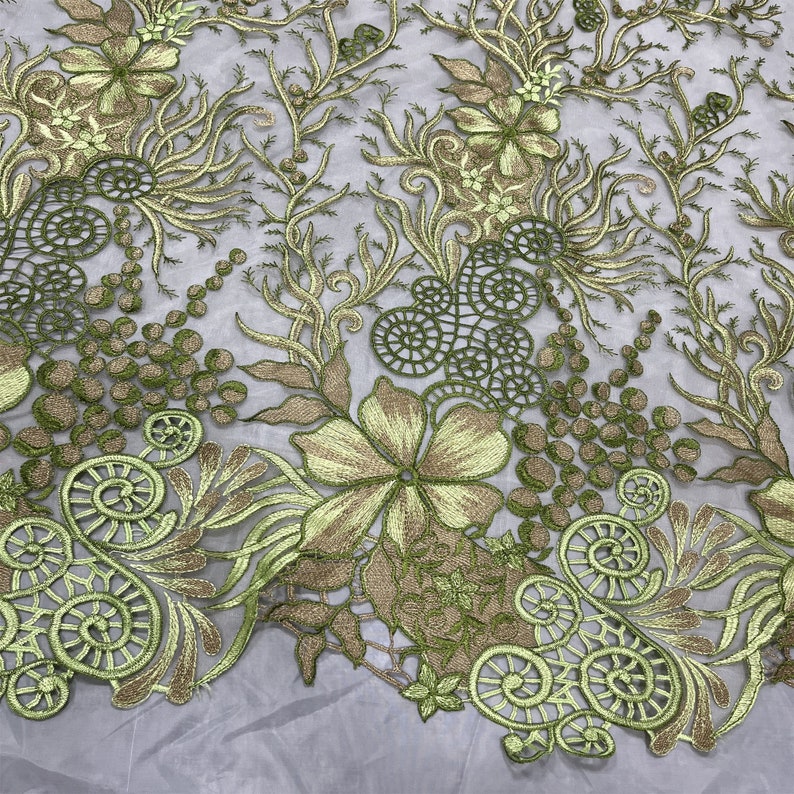K&ouml;nnte beinhalten: Gr&uuml;ne und goldene florale Stickerei auf einem durchsichtigen Netzstoff. Das Design zeigt komplizierte Wirbel, Bl&auml;tter und Blumen.