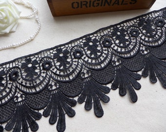 May include: Black lace trim with a scalloped edge and intricate floral designs. The lace is delicate and has a soft, flowing texture.