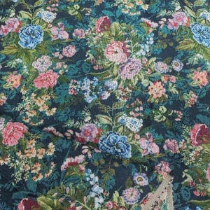 Puede incluir: Una tela tejida con un denso patr&oacute;n floral sobre un fondo verde azulado oscuro. El dise&ntilde;o incluye racimos de rosas y flores m&aacute;s peque&ntilde;as en tonos rosa, azul claro, lavanda y crema, intercalados con follaje y hojas de color verde.
