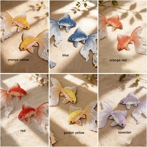 May include: A collection of embroidered goldfish patches in various colors including orange-yellow, blue, orange-red, red, golden yellow, and lavender. Each patch features detailed stitching of a fish with flowing fins and a distinct color palette.