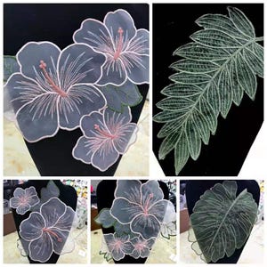 Pode incluir: Aplicações de tecido floral com desenhos de hibisco e folhas. As flores de hibisco são cinzentas com detalhes em rosa e branco, e folhas verdes. As aplicações de folhas são verdes com detalhes brancos. Ideal para artesanato.