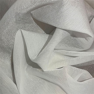 May include: White sheer fabric with a subtle sparkle. The fabric is soft and delicate, with a slightly textured surface.