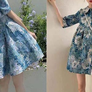 May include: Two short dresses featuring blue and teal floral patterns. The left dress has a square neckline and puff sleeves. The right dress features a rounded collar, three-quarter length sleeves, and a loose, flared silhouette with a floral print.