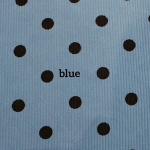 May include: A light blue fabric with a vertical ribbed texture and a repeating pattern of dark brown polka dots. The word blue is printed in black lowercase letters in the center of the fabric, positioned between two of the brown dots.