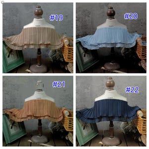 May include: Four fabric neck ruffs in different colors: tan (#19), light blue (#20), orange (#21), and navy blue (#22). Each is pleated and displayed on a mannequin bust with "PARIS" printed on it.