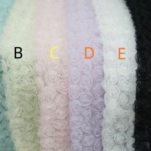 May include: Six samples of fabric with a 3D rose design. The fabric colors are light blue, light green, light pink, light purple, white, and black.