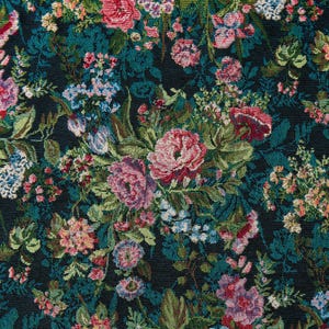 Puede incluir: Una tela tejida con un denso patrón floral sobre un fondo oscuro. El diseño incluye racimos de flores rosas, rojas y azul claro intercaladas con hojas y tallos verdes, creando un efecto de tapiz botánico detallado y con textura.