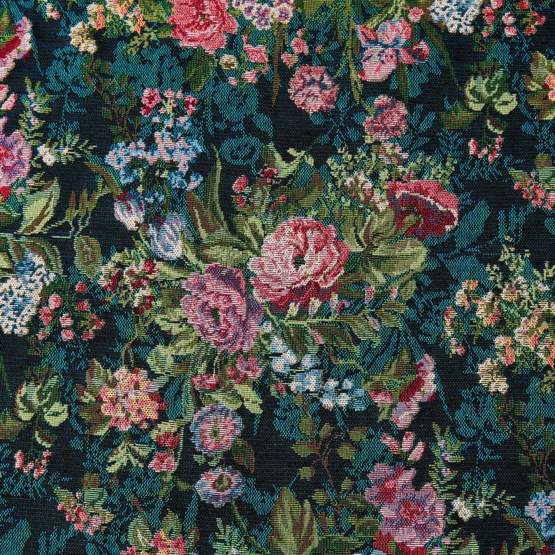 Puede incluir: Una tela tejida con un denso patr&oacute;n floral sobre un fondo oscuro. El dise&ntilde;o incluye racimos de flores rosas, rojas y azul claro intercaladas con hojas y tallos verdes, creando un efecto de tapiz bot&aacute;nico detallado y texturizado.