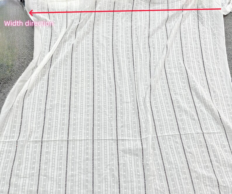 May include: White fabric with a vertical striped pattern. The fabric has a small, dotted pattern throughout.