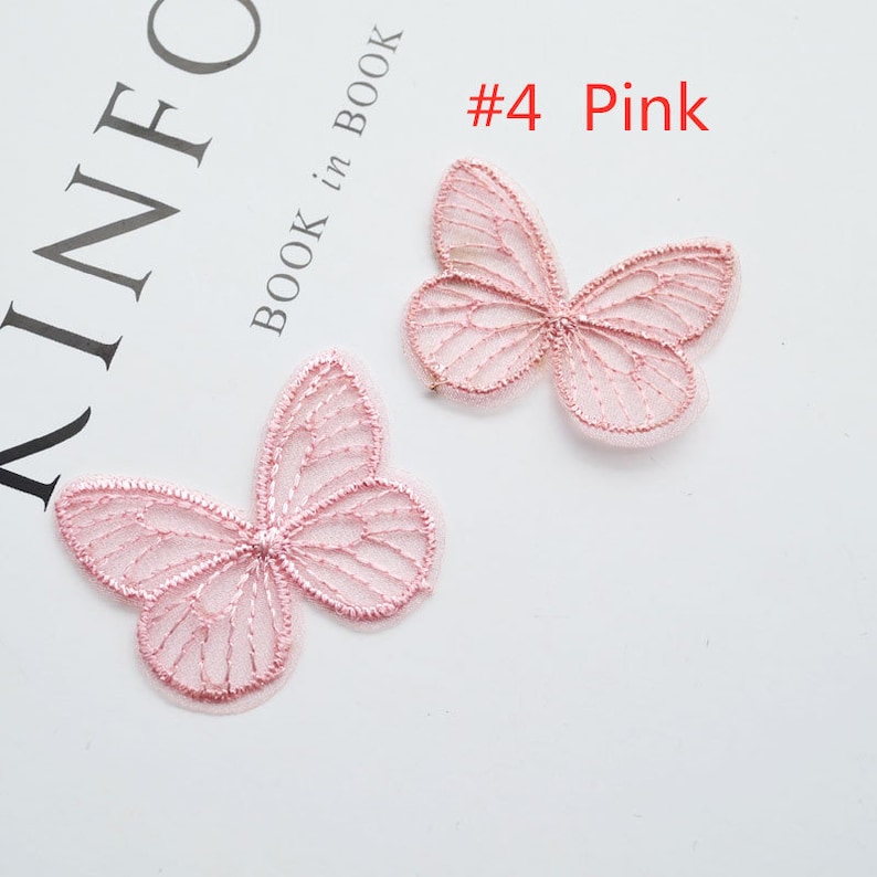 May include: Two pink lace butterfly appliques. The butterflies are delicate and intricate, with a fine mesh design. #4 Pink