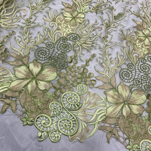 K&ouml;nnte beinhalten: Gr&uuml;ner und goldener floraler Stickerei-Spitzenstoff. Die Spitze zeigt ein zartes Blumenmuster mit Spiralen und Kreisen.