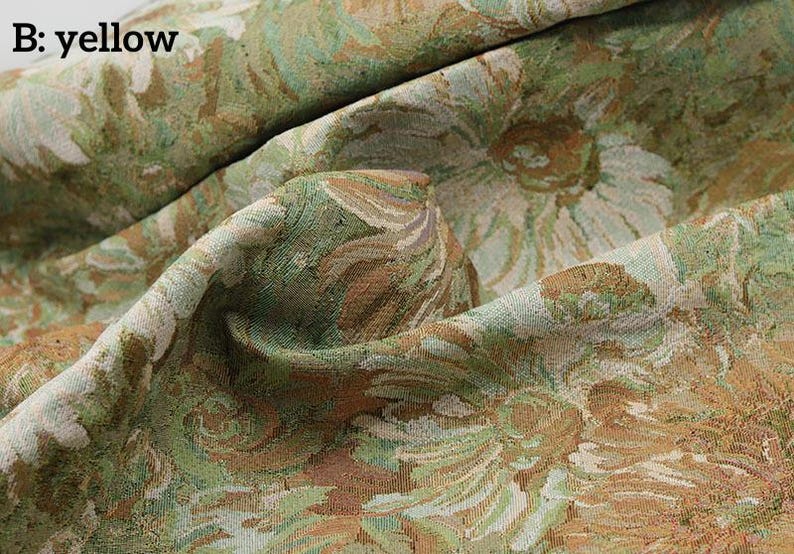 May include: A textured fabric featuring a woven floral pattern in shades of yellow, sage green, and cream. The material is draped to show its thickness and weave, with the text B: yellow printed in the upper left corner of the image.