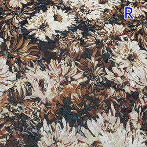 Puede incluir: Una tela tejida con un denso patr&oacute;n floral de flores color crema y blanco similares a las margaritas sobre un fondo marr&oacute;n oscuro. El dise&ntilde;o incluye la letra R en la esquina superior derecha. La textura parece un tejido de tapiz pesado.