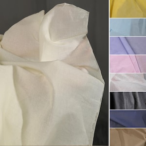 Puede incluir: Tela de color crema con un tejido texturizado, drapeada y doblada. Una selección de muestras de tela en amarillo, azul, morado, rosa, blanco, negro, azul marino y beige se muestra a la derecha.