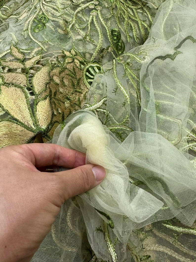 K&ouml;nnte beinhalten: Gr&uuml;ner und goldener T&uuml;llstoff mit einer zarten Blumenmuster-Stickerei.