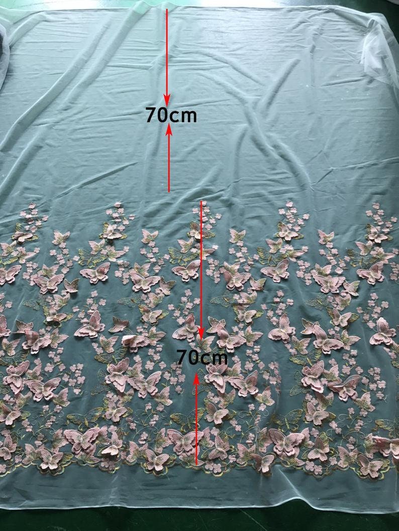Pu&ograve; includere: Un tessuto di tulle azzurro chiaro con ricamo di farfalle 3D rosa. Il tessuto misura 70 cm x 70 cm.