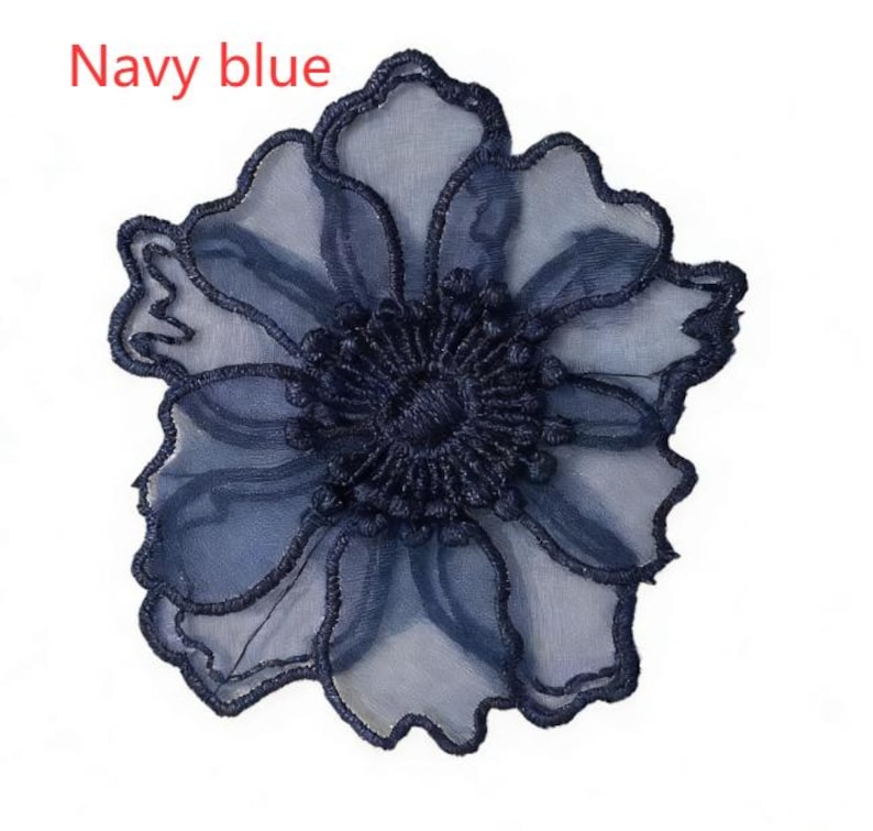 May include: A navy blue flower applique featuring sheer, translucent petals with embroidered edges and a dense, textured center. The text "Navy blue" is printed in the upper left corner of the image, identifying the color of the floral design.