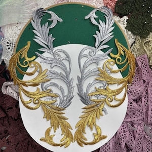 Peut inclure: Deux appliques en tissu décoratives en or et argent. Les appliques présentent des motifs floraux complexes avec des motifs en spirale.