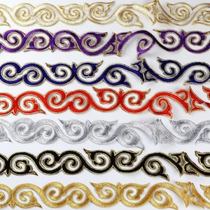 May include: A selection of embroidered trims in a range of colours. The trims display a repeating scroll pattern with gold, purple, blue, red, silver, black, and gold detailing. Ideal for embellishing clothing, accessories, or home decor projects.