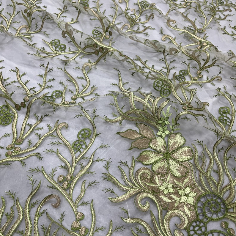 K&ouml;nnte beinhalten: Gr&uuml;ner, gestickter Blumenspitzenstoff mit einem zarten Muster aus Bl&auml;ttern und Bl&uuml;ten. Die Spitze ist durchsichtig und hat eine weiche, flie&szlig;ende Textur.
