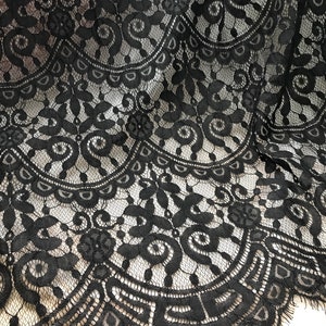 Puede incluir: Tela de encaje negra con un delicado patr&oacute;n floral. El encaje tiene un borde festoneado.