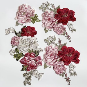 以下が含まれることがあります： ピンク、赤、白、緑の色合いの刺繍された花のパッチ。 パッチは、詳細な牡丹やその他の花のデザイン、緑の葉と繊細な白いアクセントが特徴です。 生地装飾に最適です。