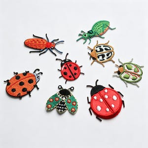 May include: A collection of eight embroidered insect patches featuring various designs including ladybugs in red with black or white spots, a long orange beetle, a green beetle, a patterned tan beetle, and a green and black moth-like insect.
