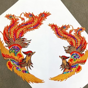 May include: Two embroidered phoenix patches. The patches feature a vibrant design with red, gold, and brown colors. The phoenixes have detailed wings and tails, with colorful sequin accents. The patches are on a white background.