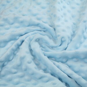 May include: A close-up of a light blue fabric with a textured, bubble-like pattern. The fabric is soft and plush, and it is perfect for use in a variety of projects.