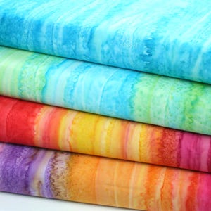 May include: Four fabric swatches in a rainbow gradient, starting with a light blue, then green, then orange, then purple. The fabric has a watercolour-like pattern with streaks of colour.