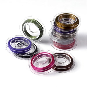 Peut inclure: Bobines de fil coloré pour la fabrication de bijoux. Les bobines sont en plastique transparent avec un fil métallique de différentes couleurs, notamment vert, or, violet, rose, marron, argent et rouge.
