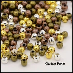 Può includere: Una collezione di piccole perline rotonde in varie finiture metalliche, tra cui oro, argento, bronzo e rame. Le perline hanno un foro al centro, adatto per essere infilate. L'immagine include il testo "Clarisse-Perles".