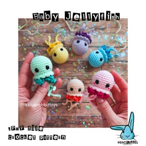 Peut inclure: Plusieurs méduses crochetées à la main, aux couleurs vives, dont du vert menthe, du jaune, du violet et du rose. Le texte "Baby Jellyfish" est affiché au-dessus des jouets. Le texte "PDF file Crochet pattern" est également présent.