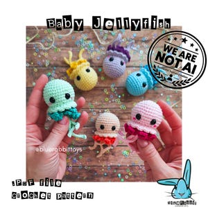May include: A collection of six small, handmade crochet jellyfish toys in various colors including mint, yellow, purple, blue, beige, and pink. Each jellyfish features black safety eyes, pink blush details, and dangling tentacles. Text reads Baby Jellyfish, PDF file crochet pattern, and We Are Not AI.