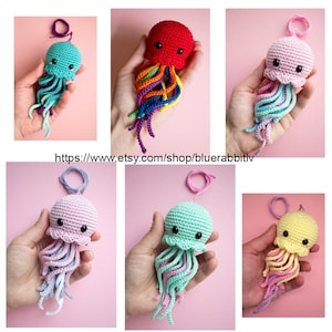 May include: A collection of six small, handmade crochet jellyfish ornaments, each featuring a rounded head with black bead eyes and multiple dangling, wavy tentacles in various color combinations including red, pink, yellow, and teal.