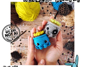 Può includere: Due piccoli vasi a forma di polpo realizzati in filato all'uncinetto, uno blu brillante e uno grigio chiaro, con parte superiore gialla testurizzata, occhi di sicurezza neri e bocca sorridente. Il testo recita OCTOPUS PLANTER e PDF file crochet pattern.