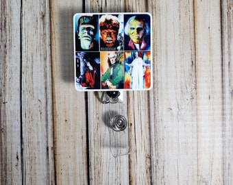 May include: A square badge reel featuring a collage of classic monster movie characters. The images include Frankenstein's monster, the Wolfman, and Dracula, among others. The reel has a clear plastic strap and a metal clip.
