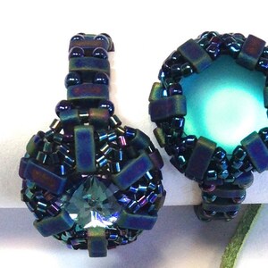 Op de afbeelding: Twee iriserende blauwe en zwarte kralenringen met een turquoise steen in het midden van elke ring.