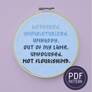 May include: A cross-stitch embroidery hoop with the words "MOTHERED. UNMOISTURIZED. UNHAPPY. OUT OF MY LANE. UNFOCUSED. NOT FLOURISHING." in black and blue thread. A PDF pattern logo is in the lower right corner.