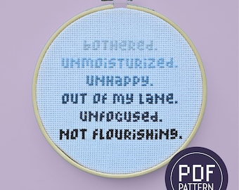 May include: A cross-stitch embroidery hoop with the words "MOTHERED. UNMOISTURIZED. UNHAPPY. OUT OF MY LANE. UNFOCUSED. NOT FLOURISHING." in black and blue thread. A PDF pattern logo is in the lower right corner.