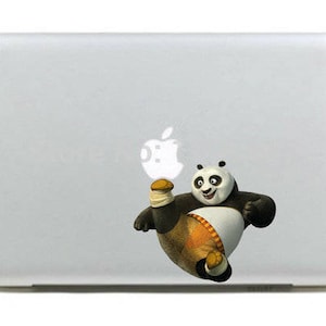 Może przedstawiać: Biały laptop z czarno-białym kreskówkowym pandą w pomarańczowych spodenkach kopiącym białe jabłko. Panda znajduje się na białym tle.