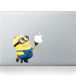May include: A silver laptop computer with a yellow and blue cartoon character holding an apple sticker on the lid.