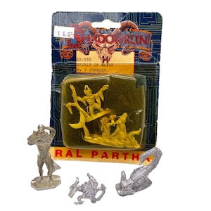 May include: A set of four miniature metal figurines, including a spirit of water, a scorpion, and two other figures. The figures are packaged in a clear plastic blister pack with a Shadowrun logo and the text "Spirit of Water by J Johnson".