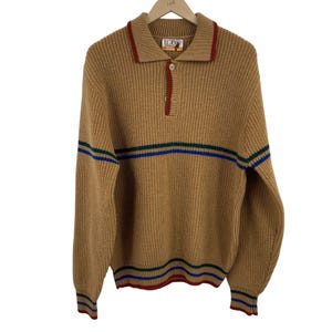 May include: A brown striped sweater with a red and green collar and a single button closure. The sweater is made of a knit fabric and has long sleeves.