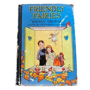 May include: A vintage children's book titled "Friendly Fairies" by Johnny Gruelle, author of the Raggedy Ann books. The cover features a colorful illustration of a fairy, children, and fairies in a whimsical setting.