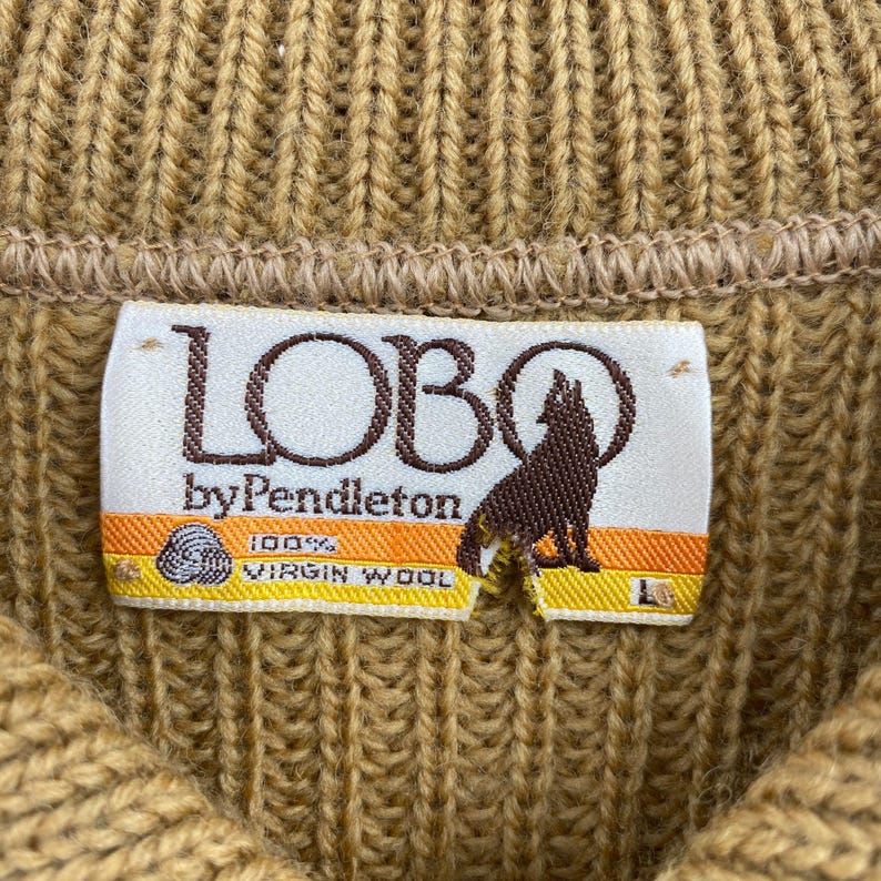 May include: A brown knit sweater with a label that reads "LOBO by Pendleton 100% VIRGIN WOOL".